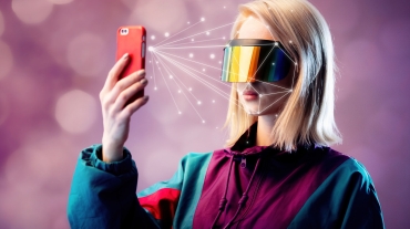 Blonde in VR glasses hold mobile phone with face scanning algorithm