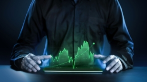 Business man showing profitable stock market holographic technology graphs in modern work background for the future. Company managers in concept planning and managing global marketing and investment.