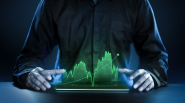 Business man showing profitable stock market holographic technology graphs in modern work background for the future. Company managers in concept planning and managing global marketing and investment.